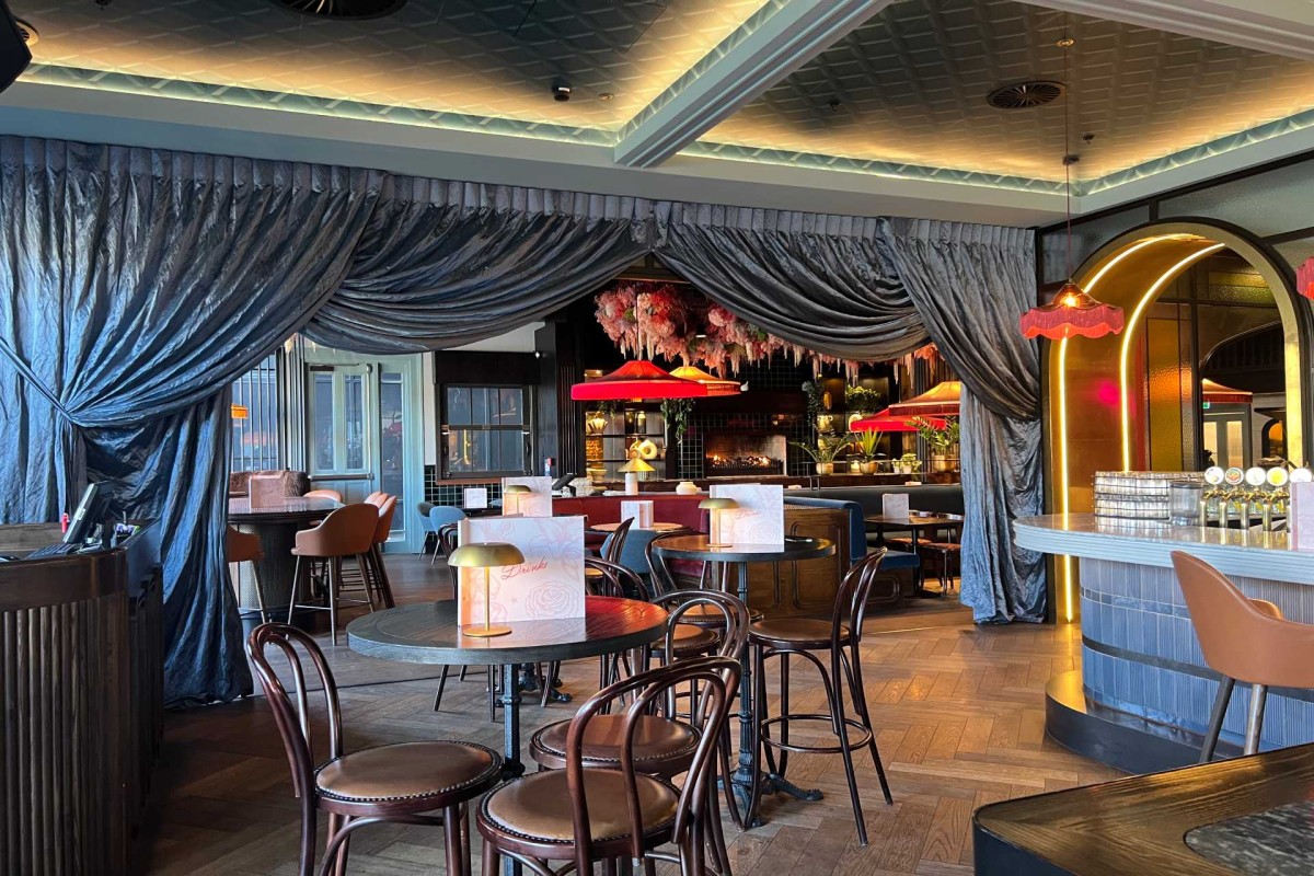 Stylish restaurant interior with draped curtains, tables, and warm lighting