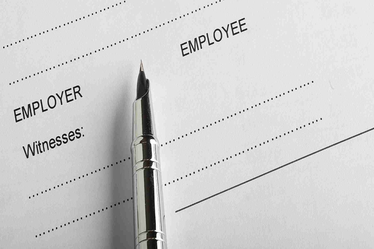 Close-up of a pen on an employment contract with spaces for employer and employee signatures