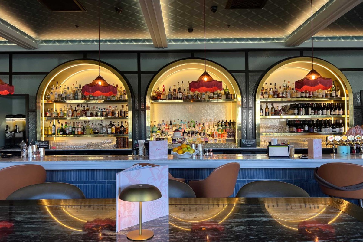 Modern bar interior with bottles on shelves and warm lighting