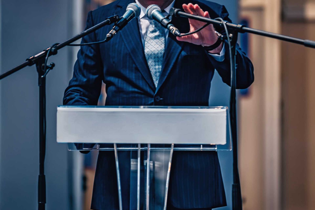 Person speaking at a podium with microphones