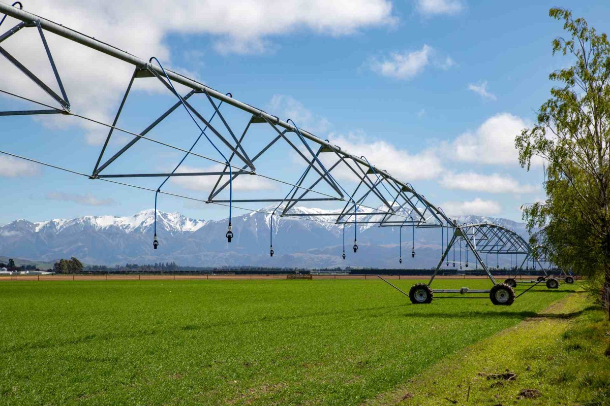 Center pivot irrigation system watering a green farm field