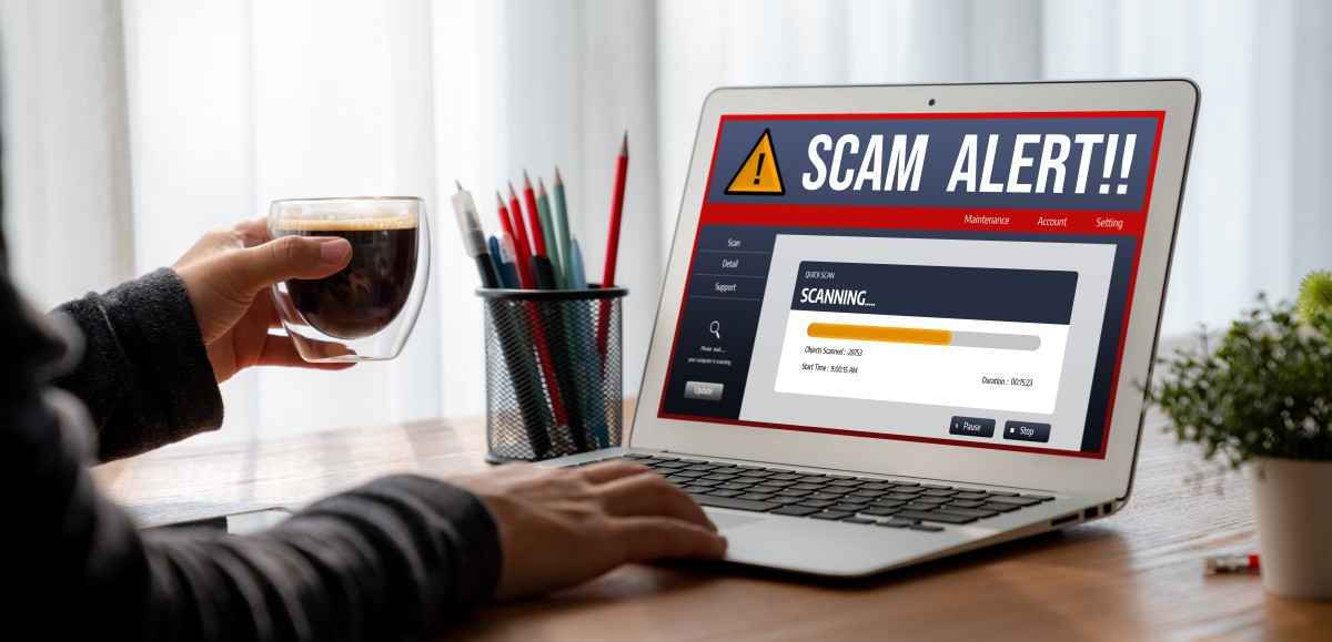 Man looking at a scam alert on his laptop