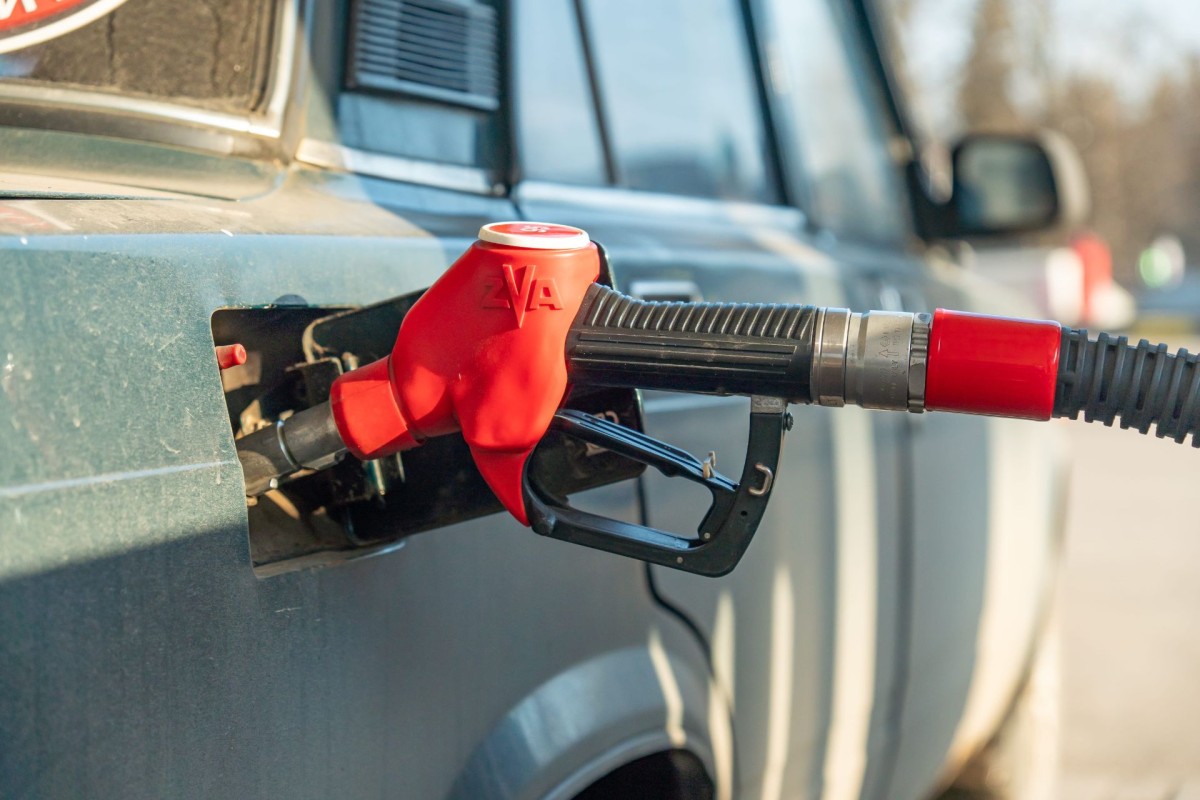Red fuel nozzle in car tank.