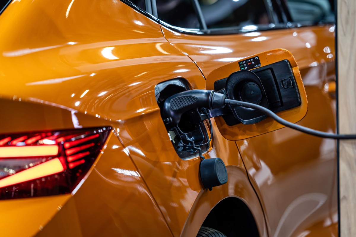 Orange electric car plugged into a charging station