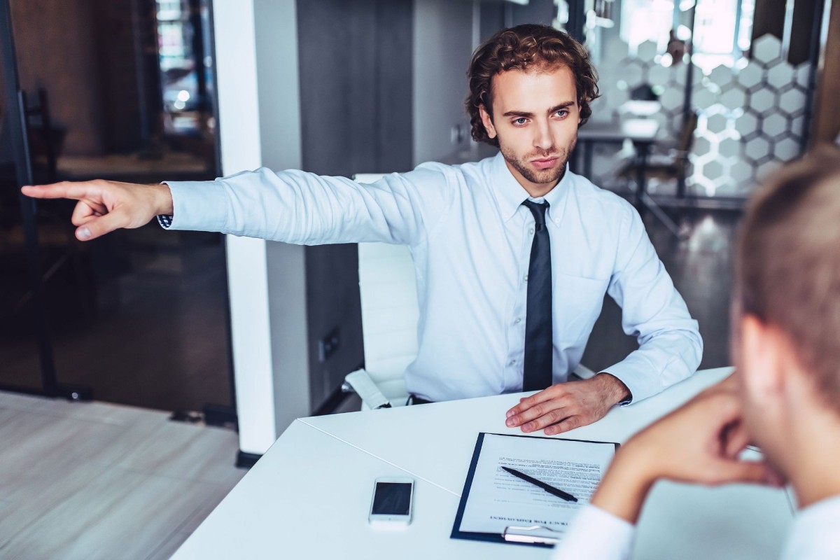 Manager discussing workplace expectations with an employee across a desk