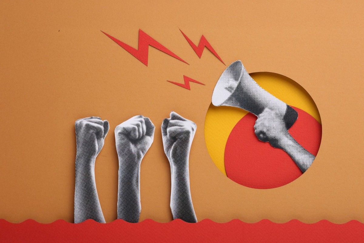 Paper-cut style illustration of raised fists and a megaphone, representing propaganda, public influence and information manipulation.