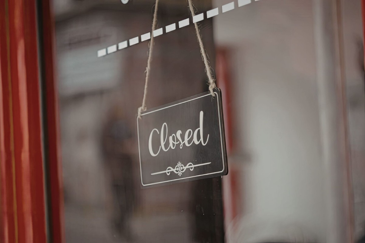 Closed sign hanging in the window of a hospitality business, illustrating business closures in New Zealand.